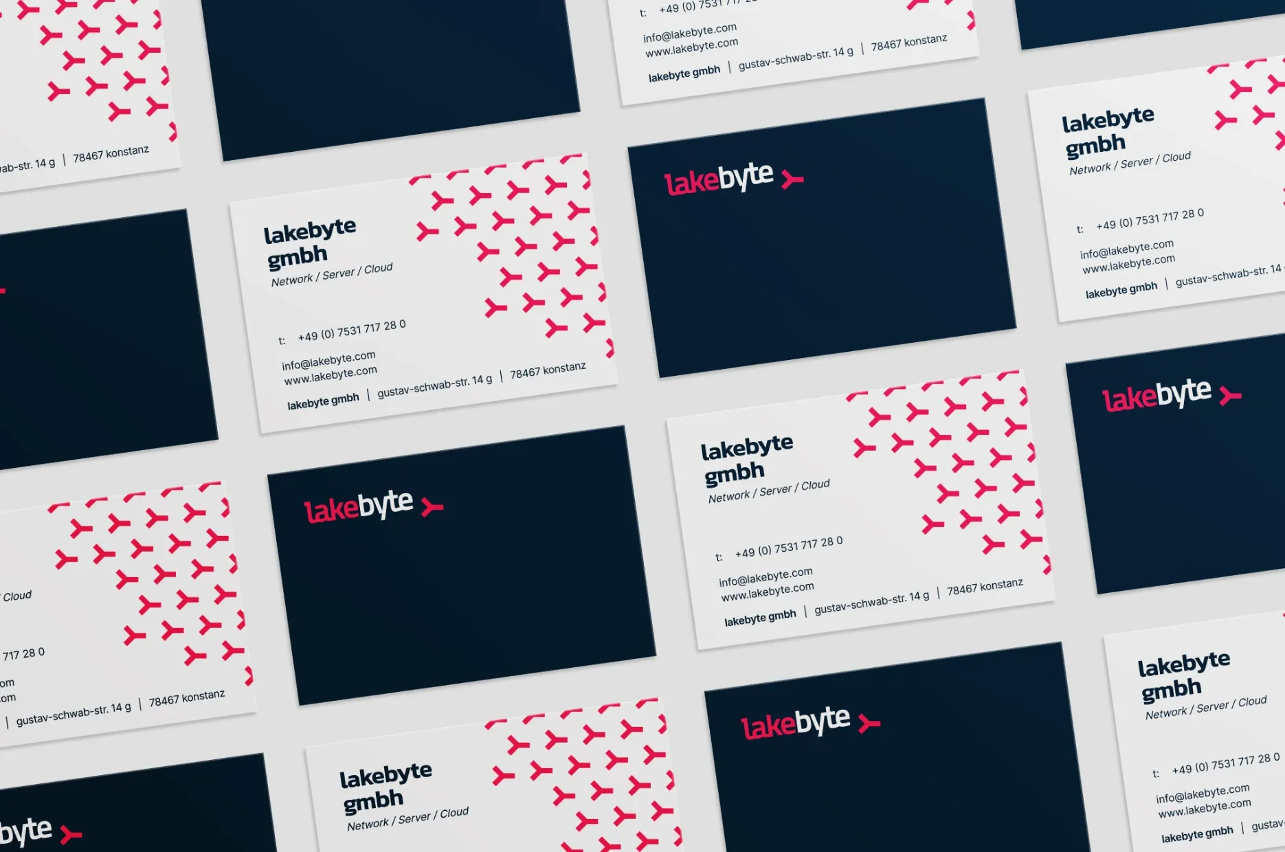 Gestreute Visitenkarten von lakebyte in Dunkelblau und Weiß mit pinkem Muster und Logo.